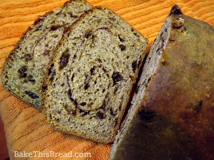 Slicing cinnamon swirl bread overhead by bake this bread