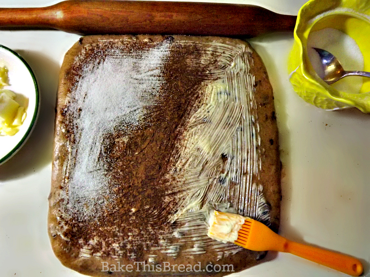 Spreading butter cinnamon and sugar on cinnamon bread dough by bake this bread